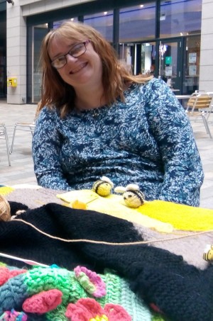 A portrait of the late Angela Joss, smiling, taken while she was helping to yarnbomb a tree.