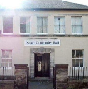 A photo of Dysart Community Hall, a two-story white building with a large front door and windows on both levels.