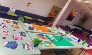 A photo of a crafting space, with no people, set up with tables and materials ready for a range of crafting projects.
