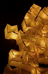 A photo of floating paper lanterns glowing on dark water.
